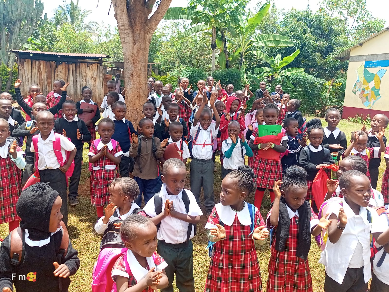 A large group of pupils cheering outdoors
