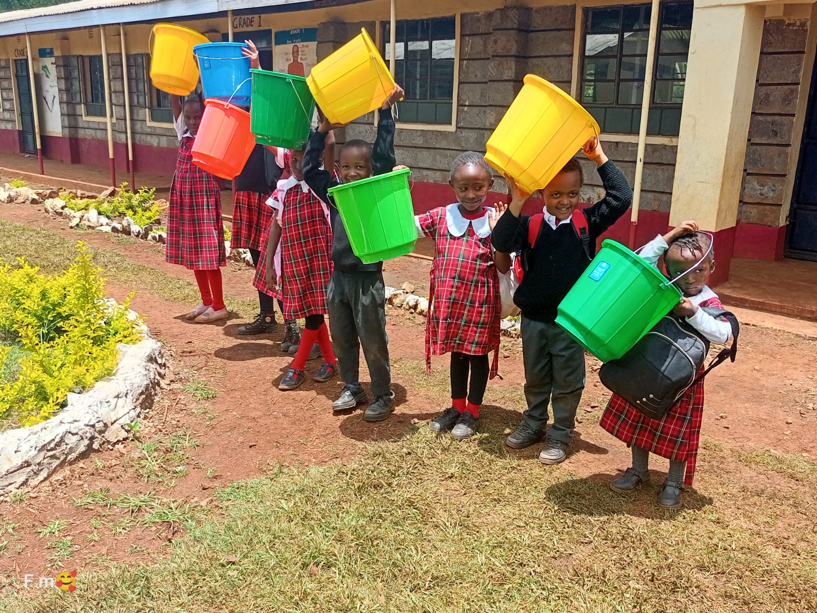 Pupils holding up colourful buckets